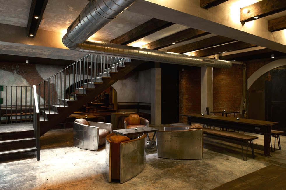 Back bar against exposed brick, with track lighting on conduit