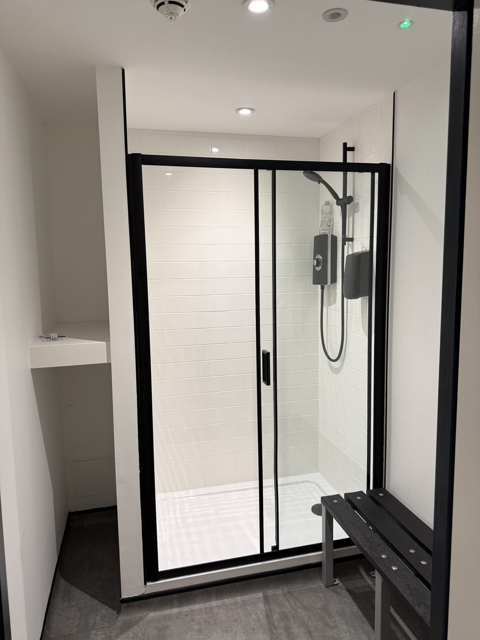 Shower cubicle — metro tiles, black-framed sliding screen and bench
