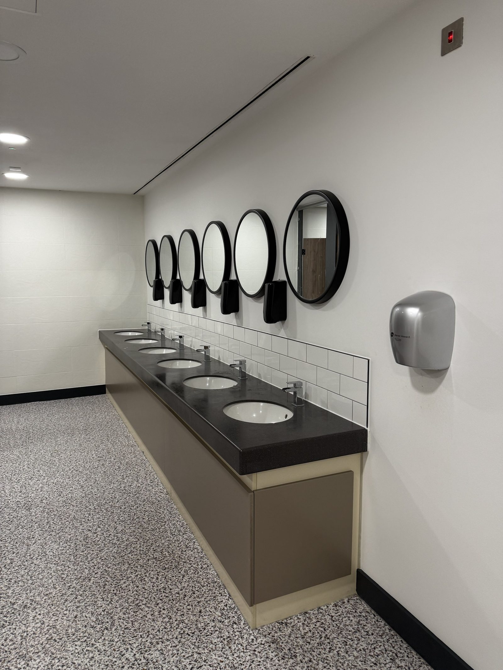 Six-basin vanity run under round mirrors