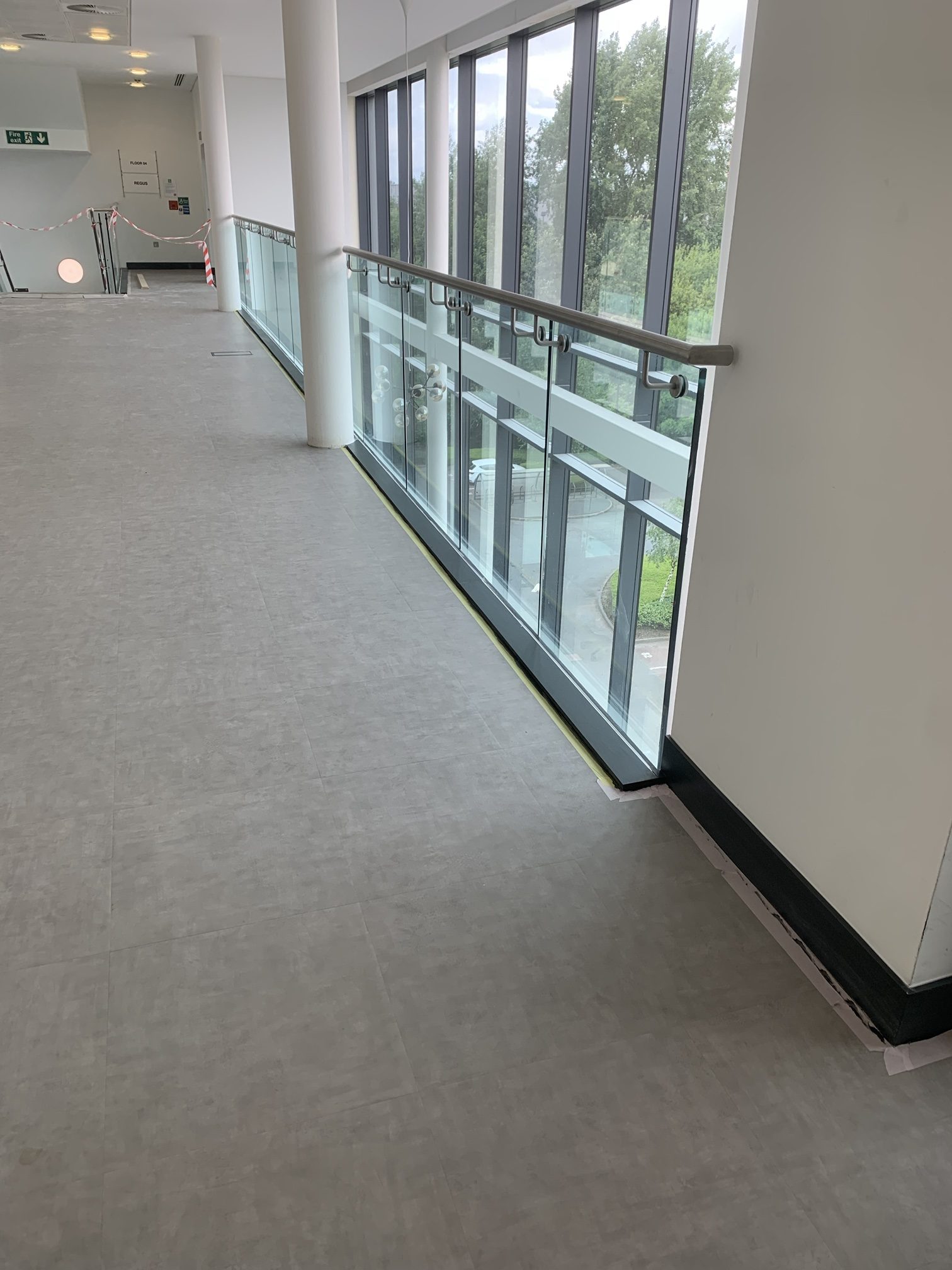 Atrium walkway re-floored in grey LVT along the glass balustrade