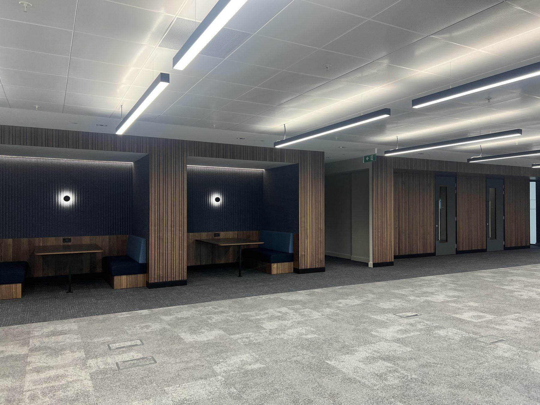 Walnut slat booths with acoustic backs and integrated power